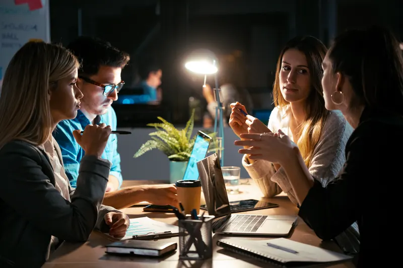 A small team in an evening discussion around a table