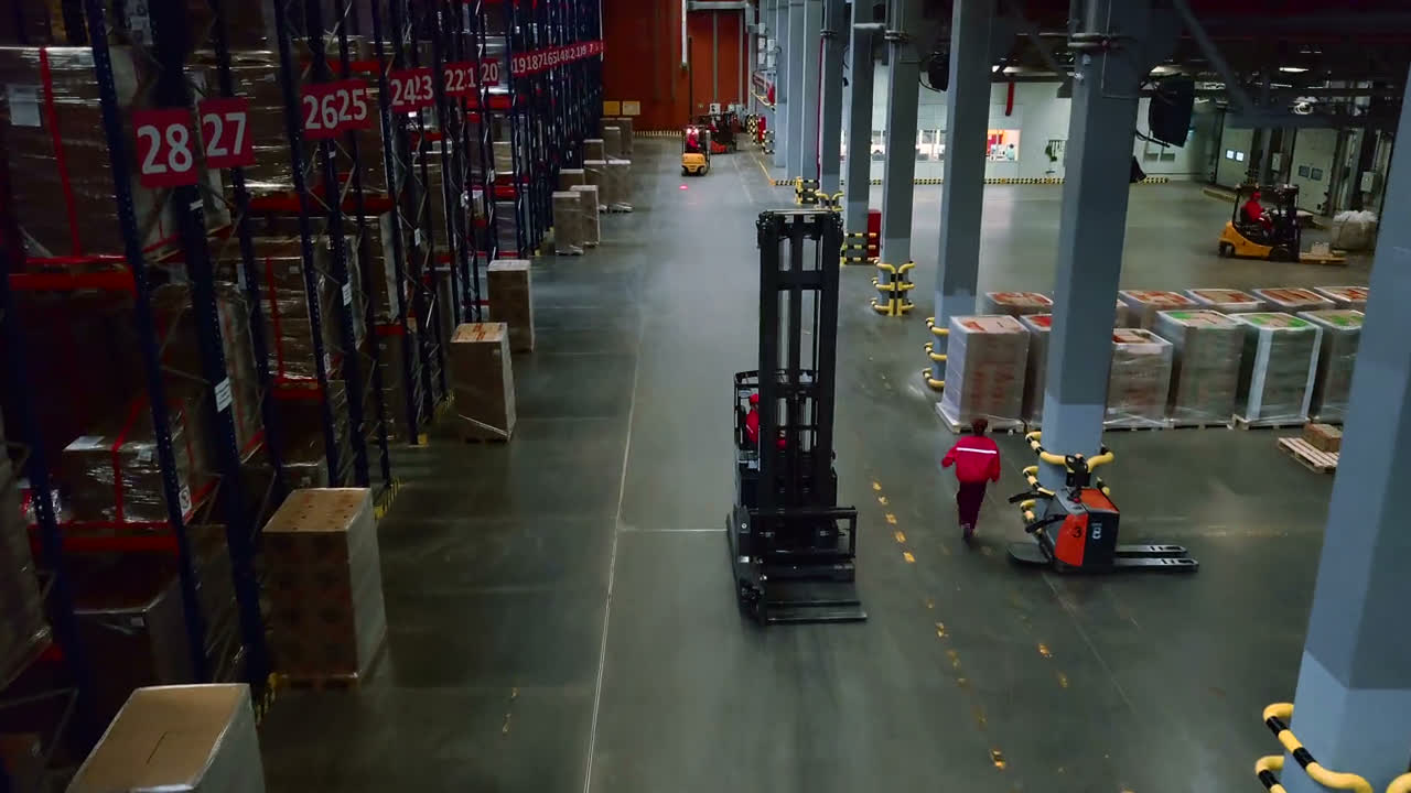 Forklifts moving pallets through a large warehouse